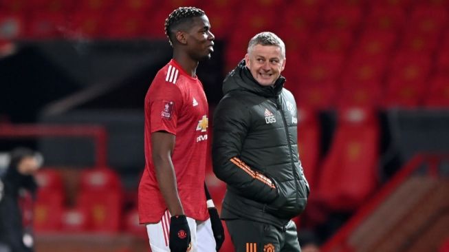 Manajer Manchester United, Ole Gunnar Solskjaer (kanan) berbincang dengan gelandang Paul Pogba usai laga Piala FA 2020/2021 kontra Liverpool di Old Trafford, Manchester, Senin (25/1/2021) dini hari WIB. [LAURENCE GRIFFITHS / POOL / AFP]