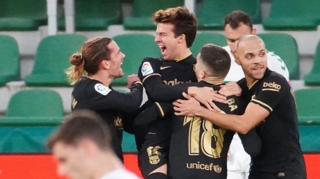 Para pemain Barcelona merayakan gol Riqui Puig (tengah) ke gawang Elche dalam pertandingan Liga Spanyol di Martinez Valero stadium. JOSE JORDAN / AFP