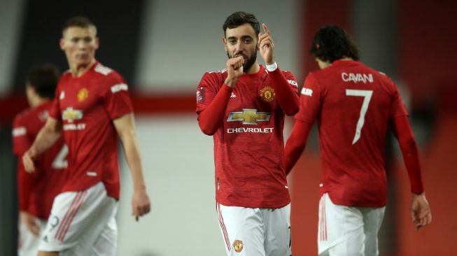 Gelandang serang Manchester United, Bruno Fernandes (tengah) melakukan selebrasi usai mencetak gol ke gawang Liverpool dalam laga Piala FA 2020/2021 di Old Trafford, Senin (25/1/2021). [MARTIN RICKETT / POOL / AFP]