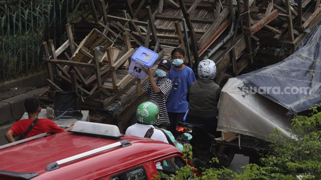 Warga mengenakan masker berjalan di kawasan Pasar Minggu, Jakarta, Selasa (26/1/2021). [Suara.com/Angga Budhiyanto]