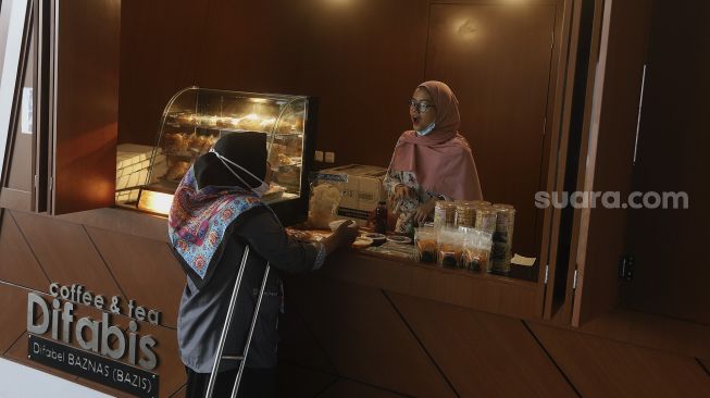 Pedagang disabilitas menunggu pembeli di kedai Difabis Coffee & Tea, kawasan Terowongan Kendal, Jakarta Pusat, Selasa (26/1/2021). [Suara.com/Angga Budhiyanto]