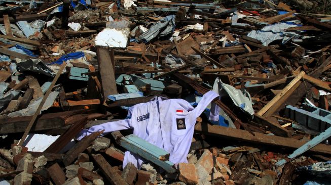 Seragam sekolah tergeletak di puing bangunan sekolah SMK 1 Rangas yang roboh pasca gempa bumi di Mamuju, Sulawesi Barat, Selasa (26/1/2021). [ANTARA FOTO / Akbar Tado]
