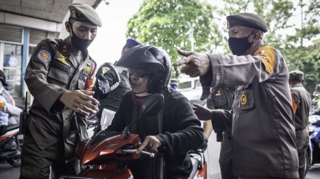 Petugas Satpol PP menggelar razia masker dalam rangka pengawasan PSBB ketat di kawasan Kampung Melayu, Jakarta Timur, Senin (7/9/2020). [ANTARA FOTO/Aprillio Akbar]