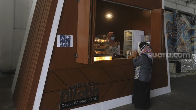 Pedagang disabilitas menunggu pembeli di kedai Difabis Coffee & Tea, kawasan Terowongan Kendal, Jakarta Pusat, Selasa (26/1/2021). [Suara.com/Angga Budhiyanto]