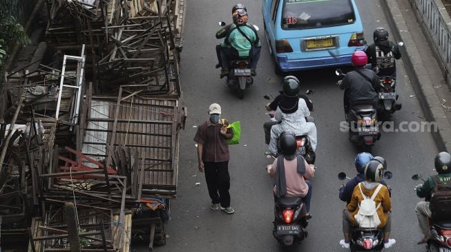 Warga mengenakan masker berjalan di kawasan Pasar Minggu, Jakarta, Selasa (26/1/2021). [Suara.com/Angga Budhiyanto]