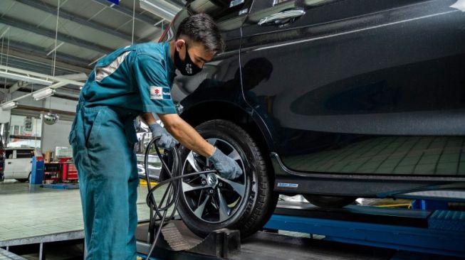 Seorang mekanik bengkel resmi Suzuki tengah menangani kendaraan konsumen saat general check-up [PT Suzuki Indomobil Sales].