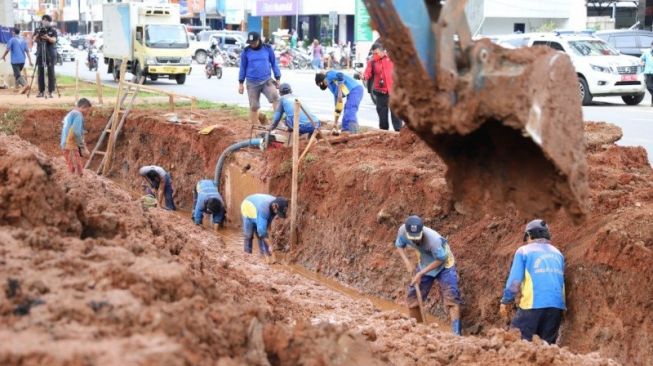 Petugas Suku Dinas Sumber Daya Air mengerjakan pembuatan kolam olakan di Jalan Boulevard Raya, Kelapa Gading, Jakarta Utara, Rabu (27/1/2021). [Dok. Kominfotik Jakarta Utara]