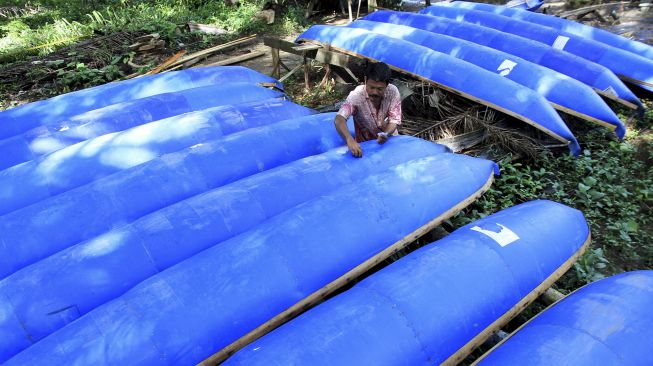 Perajin menyelesaikan proses pembuatan perahu nelayan berbahan dasar drum plastik bekas di Desa Teupin Perahu, Kecamatan Arongan Lambalek, Aceh Barat, Aceh, Jumat (29/1/2021). [ANTARA FOTO/Syifa Yulinnas]