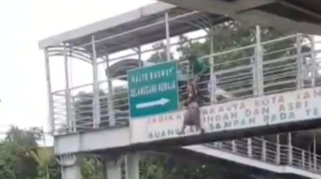 Wanita hamil nyaris melompat dari atas JPO Halte TransJakarta Gelanggang Remaja, Otista, Jaktim. (tangkap layar video amatir)