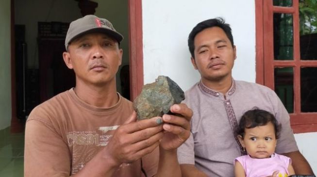 membawa air tersebut ke lokasi jatuhnya batu yang diduga meteor itu di Lampung Tengah, Jumat (29/1/2021) [Suara.com/Andry Kurniawan]