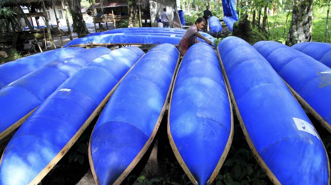 Perajin menyelesaikan proses pembuatan perahu nelayan berbahan dasar drum plastik bekas di Desa Teupin Perahu, Kecamatan Arongan Lambalek, Aceh Barat, Aceh, Jumat (29/1/2021). [ANTARA FOTO/Syifa Yulinnas]