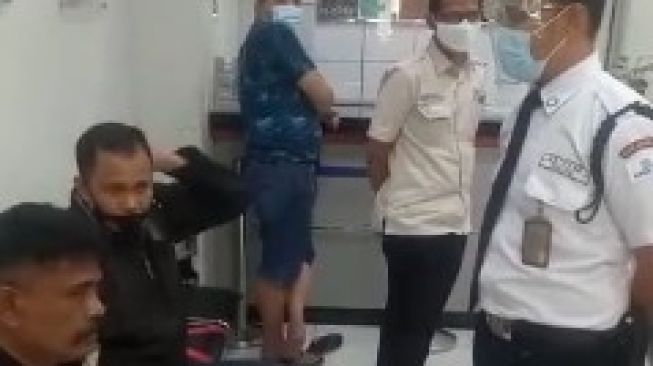 Satpam BRI KCP Makassar Sentral melarang warga masuk bank jika tidak memakai masker / [Foto Istimewa]