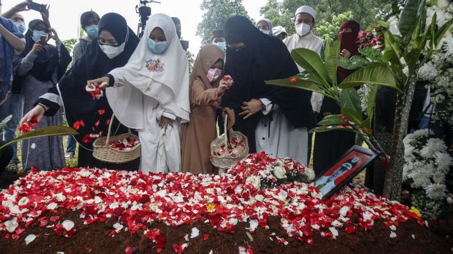 Keluarga menabur bunga di pusara Pilot Capt Afwan korban kecelakaan Sriwijaya Air PK-CLC nomor penerbangan SJ 182 di Taman Makam Pahlawan Pondok Rajeg, Kabupaten Bogor, Jawa Barat, Sabtu (30/1/2021). [ANTARA FOTO/Yulius Satria Wijaya]