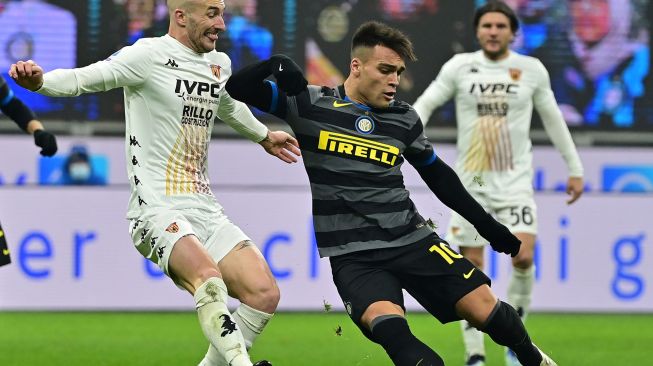 Penyerang Inter Milan Lautaro Martinez (kanan) melakukan tembakan  selama pertandingan sepak bola Serie A Italia antara Inter Milan melawan Benevento,  di Stadion Guseppe Meazza, Minggu (31/1/2021) dini hari WIB. MIGUEL MEDINA / AFP
