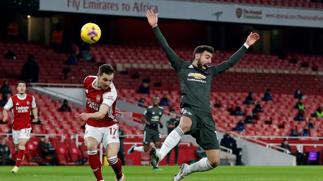 Bek Arsenal Cedric Soares (kiri) bersaing dengan gelandang Manchester United Bruno Fernandes selama pertandingan sepak bola Liga Premier Inggris antara Arsenal melawan Manchester United di Stadion Emirates, London, Sabtu waktu setempat, atau Minggu (31/1/2021) dini hari WIB. Ian KINGTON / IKIMAGES / AFP