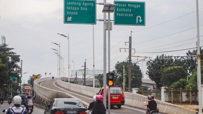 Warga mencoba membawa kendaraannya melewati Flyover Lenteng Agung di Jakarta Selatan, Minggu (31/1/2021). [Suara.com/Alfian Winanto]