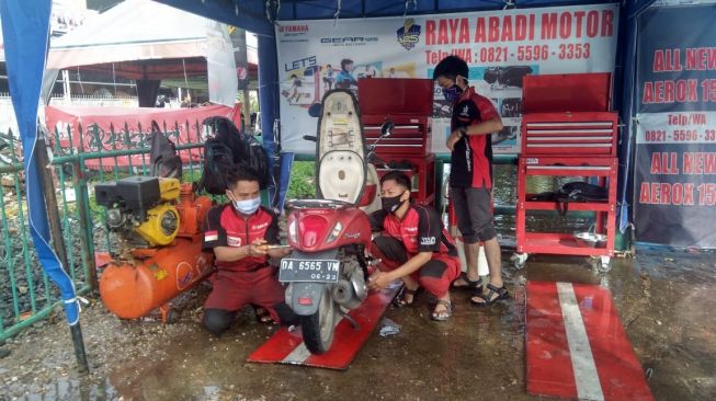 Para mekanik tengah menangani sepeda motor di posko "Yamaha Peduli Banjir Kalsel", Banjarmasin [Dok PT YIMM].