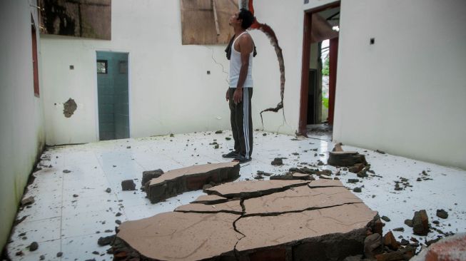 Pemilik rumah melihat kondisi rumahnya yang rusak akibat tanah bergerak di Desa Sudamanik, Lebak, Banten, Senin (1/2/2021). ANTARA FOTO/Muhammad Bagus Khoirunas