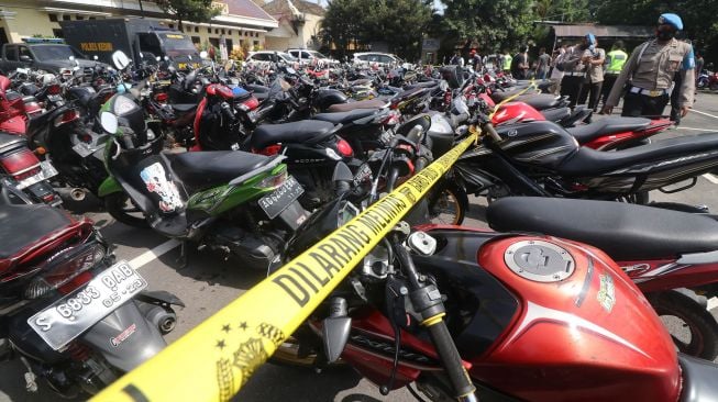 Polisi mengamati barang bukti sepeda motor hasil penindakan balap liar di Polres Kediri, Jawa Timur, Senin (1/2/2021). ANTARA FOTO/Prasetia Fauzani