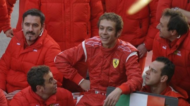 Pembalap MotoGP Valentino Rossi (tengah) berpose dengan para teknisi Ferrari setelah dia menjalani sesi uji coba menggunakan mobil Ferrari F2008 di Sirkuit Catalunya, Montmelo pada 21 Januari 2010. [AFP PHOTO/LLUIS GENE].