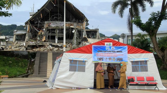 Sejumlah Aparatur Sipil Negara (ASN) beraktivitas di tenda depan kantor gubernur yang roboh di Mamuju, Sulawesi Barat, Senin (1/2/2021).  ANTARA FOTO / Akbar Tado
