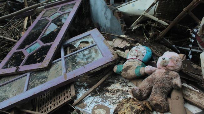 Boneka berada di reruntuhan rumah warga yang ambruk diterjang banjir bandang di Desa Banjaragung, Kecamatan Bareng, Kabupaten Jombang, Jawa Timur, Selasa (2/2/2021). ANTARA FOTO/Syaiful Arif