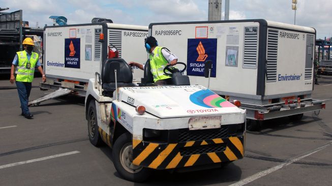 Pekerja cargo membawa Envirotainer berisi vaksin COVID-19 Sinovac setibanya dari Beijing di Terminal Cargo Bandara Soekarno Hatta, Tangerang, Banten, Selasa (2/2/2021). [ANTARA/Muhammad Iqbal]