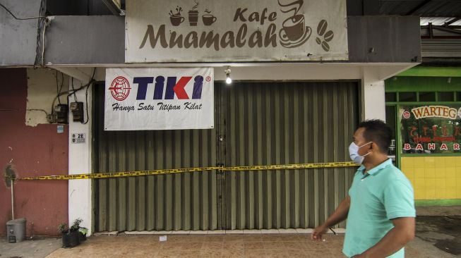 Seorang warga melintas depan ruko pasar muamalah yang disegel polisi di Tanah Baru, Depok, Jawa Barat, Rabu (3/2/2021). [ANTARA FOTO/Asprilla Dwi Adha]