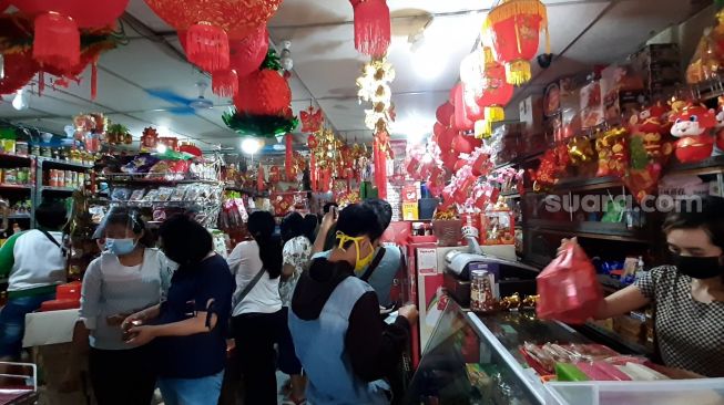 Sejumlah warga sedang membeli sejumlah pernak-pernik kebutuhan Imlek di Toko Sinar, Komplek Pasar Gedhe, Solo.[Suara.com/Budi Kusumo]