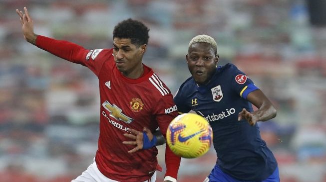 Penyerang Manchester United, Marcus Rashford (kiri) memperebutkan bola dengan gelandang Southampton Moussa Djenepo dalam laga pekan ke-22 Liga Inggris di Old Trafford, Manchester, Rabu (3/2/2021) dini hari WIB. [PHIL NOBLE / POOL / AFP]