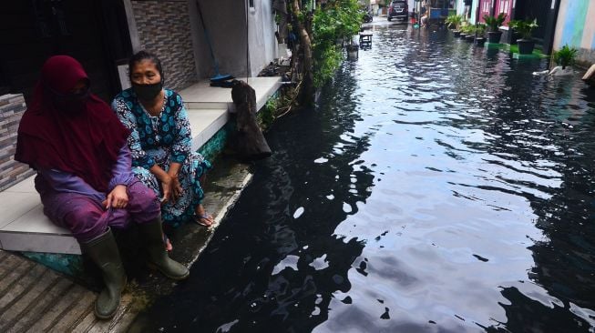 Warga mengamati kondisi air banjir yang bercampur limbah di Dusun Tanggulangin, Jati Wetan, Jati, Kudus, Jawa Tengah, Kamis (4/2/2021).  ANTARA FOTO/Yusuf Nugroho
