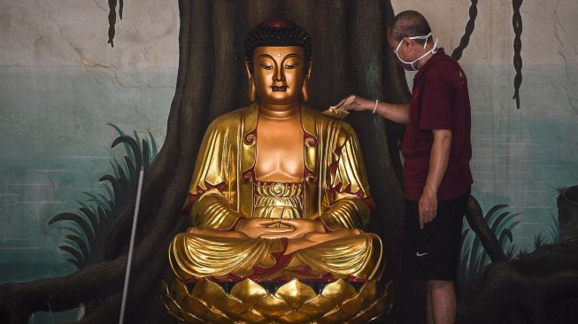 Warga membersihkan patung Gautama Buddha di Wihara Amurva Bhumi Karet, Jakarta, Kamis (4/2/2021). ANTARA FOTO/Muhammad Adimaja
