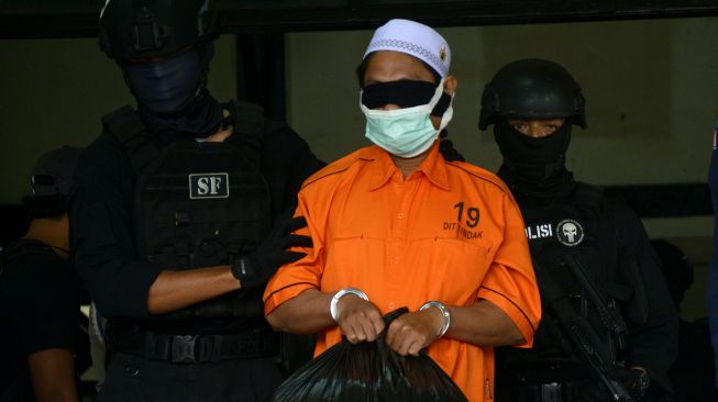 Tim gabungan Detasemen Khusus (Densus) 88 Antiteror Mabes Polri dan Brimob Polda Sulsel menggiring tersangka teroris saat akan diberangkatkan ke Jakarta di Bandara lama Sultan Hasanuddin, Kabupaten Maros, Sulawesi Selatan, Kamis (4/2/2021). ANTARA FOTO/Abriawan Abhe