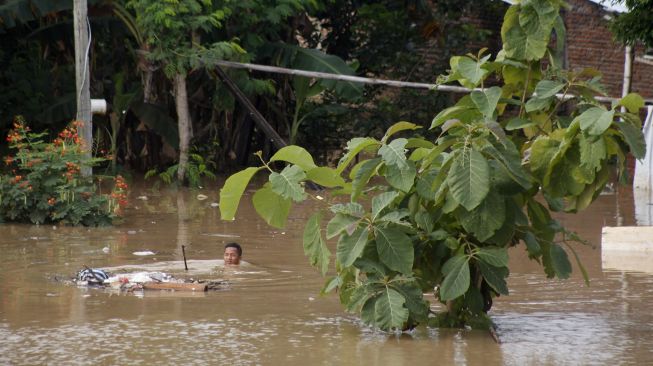 Warga menyelamatkan perabot rumah tangga miliknya saat banjir menggenangi permukiman di Kampung Sewu, Jebres, Solo Jawa Tengah, Kamis (4/2/2021).  [ANTARA FOTO/Maulana Surya]