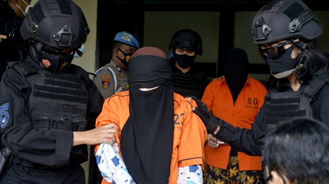 Tim gabungan Detasemen Khusus (Densus) 88 Antiteror Mabes Polri dan Brimob Polda Sulsel menggiring tersangka teroris saat akan diberangkatkan ke Jakarta di Bandara lama Sultan Hasanuddin, Kabupaten Maros, Sulawesi Selatan, Kamis (4/2/2021). ANTARA FOTO/Abriawan Abhe