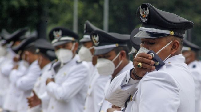 Sejumlah kepala desa terpilih memasang tanda pangkat secara mandiri dalam proses Pelantikan Kepala Desa se-Kabupaten Bogor di Lapangan Tegar Beriman, Cibinong, Kabupaten Bogor, Jawa Barat, Jumat (5/2/2021).  ANTARA FOTO/Yulius Satria Wijaya
