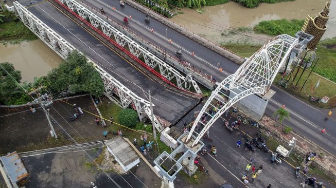 Foto udara jembatan perbatasan yang ambles di Kabupaten Pekalongan, Jawa Tengah, Jumat (5/2/2021).  ANTARA FOTO/Harviyan Perdana Putra