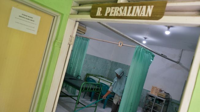 Pekerja membersihkan lantai rumah sakit khusus ibu bersalin positif COVID-19 di Klinik Permata Bhakti, Moyudan, Sleman, D.I Yogyakarta, Jumat (5/2/2021).   [ANTARA FOTO/Andreas Fitri Atmoko