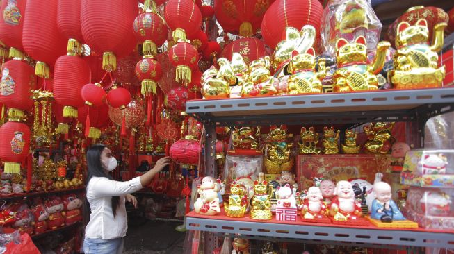 Calon pembeli memilih pernak-pernik Imlek yang dijual di Pasar Glodok, Jakarta, Sabtu (6/2/2021). [ANTARA FOTO/Reno Esnir]