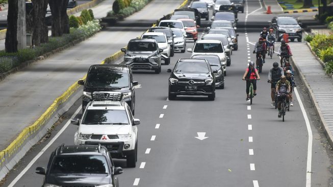 Rombongan pesepeda melintas di jalur kendaraan bermotor Jalan Sudirman, Jakarta, Sabtu (6/2/2021). ANTARA FOTO/Galih Pradipta

