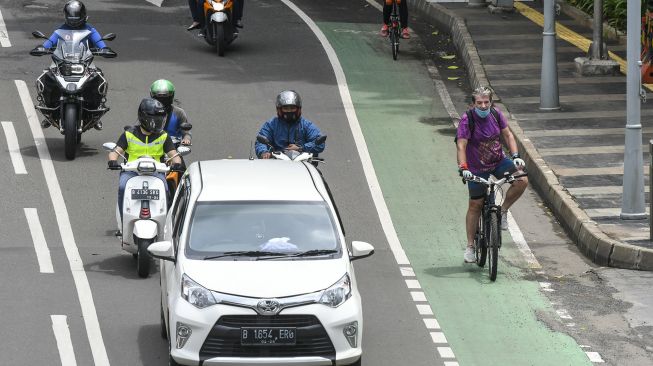 Pesepeda melintasi jalur sepeda di Jalan MH Thamrin, Jakarta, Sabtu (6/2/2021). ANTARA FOTO/Galih Pradipta
