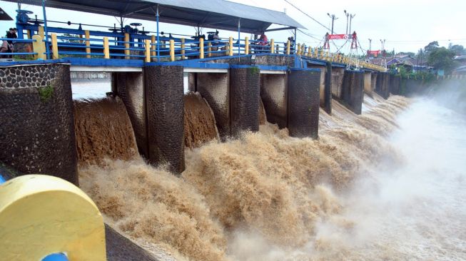 Pengendara motor melaju di atas jembatan Bendung Katulampa, Kota Bogor, Jawa Barat, Minggu (7/2/2021). ANTARA FOTO/Arif Firmansyah