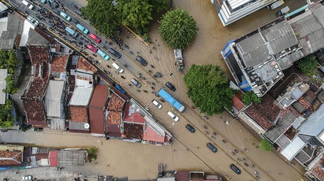 Foto aerial kendaraan melintasi banjir di Jalan Jatinegara Barat, Kampung Pulo, Jakarta, Senin (8/2/2021).  [ANTARA FOTO]
