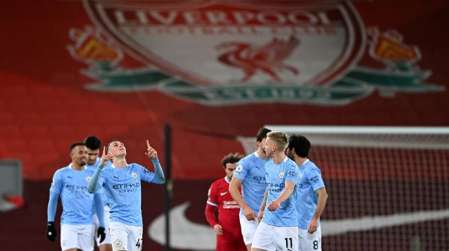 Gelandang Manchester City Phil Foden (kiri) merayakan gol keempat mereka selama pertandingan sepak bola Liga Premier Inggris antara Liverpool melawan Manchester City di Stadion Anfield, Liverpool, Inggris, Senin (8/2/2021) dini hari WIB. Laurence Griffiths / POOL / AFP
