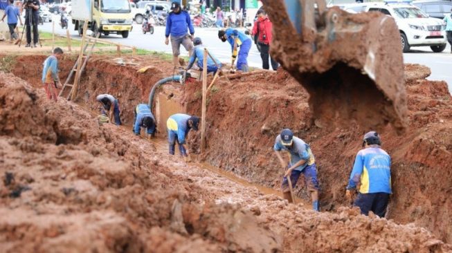 Petugas Suku Dinas Sumber Daya Air mengerjakan pembuatan kolam olakan di Jalan Boulevard Raya, Kelapa Gading, Jakarta Utara, Rabu (27/1/2021) [ANTARA/HO-Kominfotik Jakarta Utara]