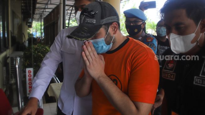 Penyanyi Ridho Rhoma dibawa masuk kedalam usai rilis kasus narkoba yang menjeratnya di Polres Pelabuhan Tanjung Priok, Jakarta Utara, Senin (8/2/2021). [Suara.com/Alfian Winanto]