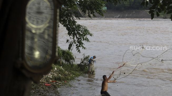 Warga menjaring ikan di Sungai Cisadane yang berada di lingkungan Kampung Tehyan, Kota Tangerang, Banten, Selasa (9/2/2021). [Suara.com/Angga Budhiyanto]