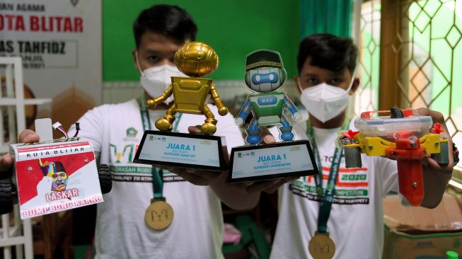 Tim robotik Laskar Bumi Bung Karno menunjukkan piala penghargaan yang diraih di ruang robotik Madrasah Tsanawiyah Negeri (MTsN) Kepanjen Kidul Blitar, Jawa Timur, Selasa (9/2/2021).  [ANTARA FOTO/Irfan Anshori]