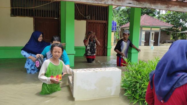 Sejumlah anak nampak tengah menerjang banjir Desa Pantai Bahagia, Muara Gembong, Kabupaten Bekasi.(Dok/Pemerintah Desa Pantai Bahagia)
