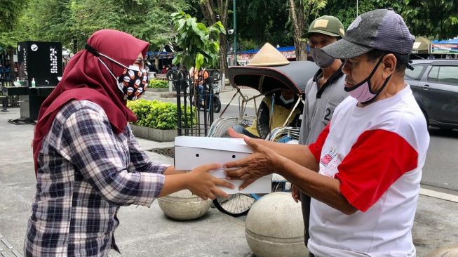 Peringati HPN, Jurnalis Jogja Bagikan Nasi Kotak ke Supir Becak Malioboro